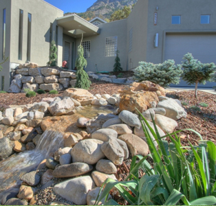 backyard landscaping with large home in background