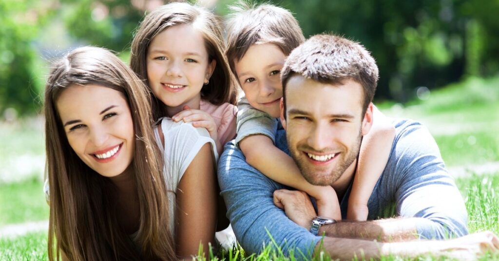 happy family laying in grass