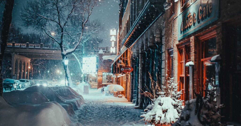 very snowy sidewalk in front of businesses