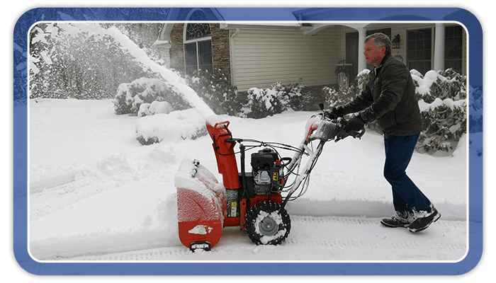 Image of a man using a snowblower to clear his driveway