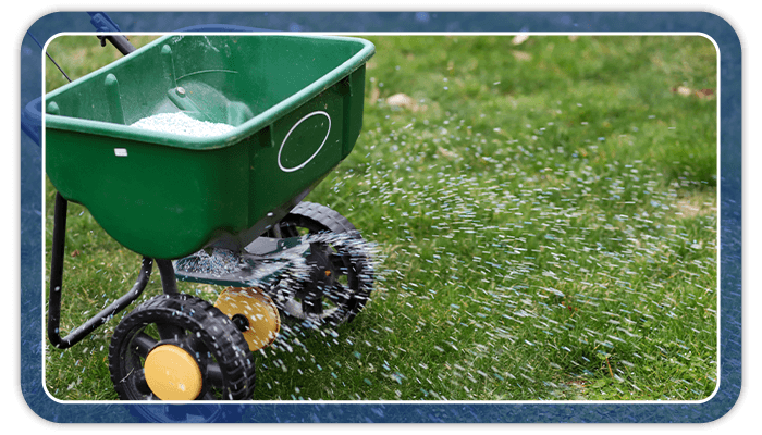 Image of a fertilizer spreader fertilizing a lawn